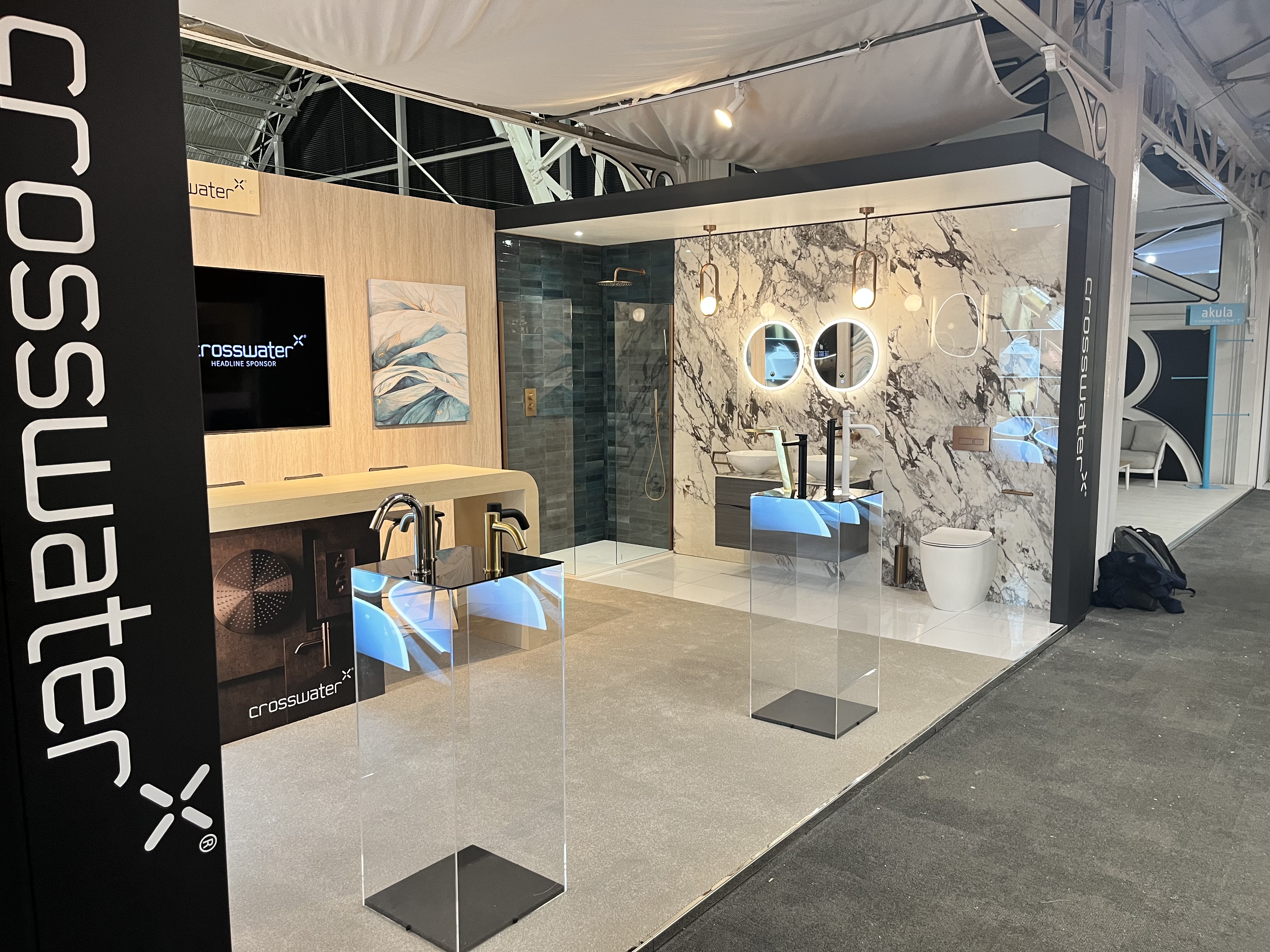Crosswater glass-walled bathroom display with marble backwall at HIX 2023
